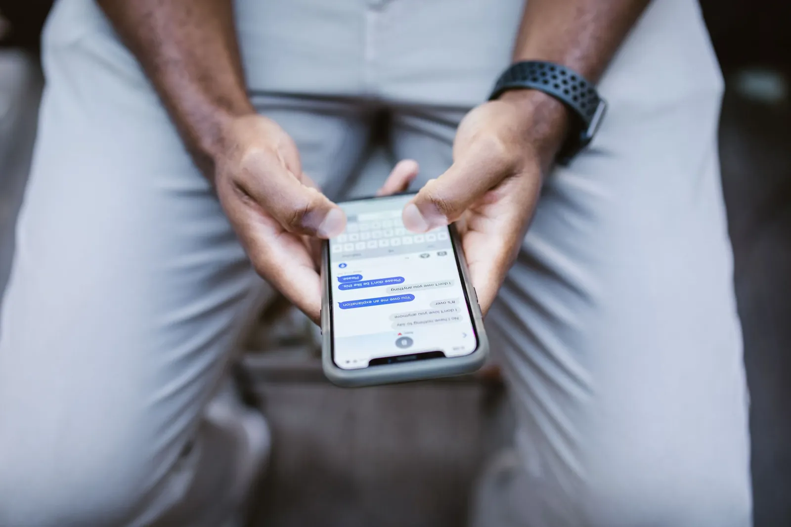 Thumbs typing an SMS message on a smartphone