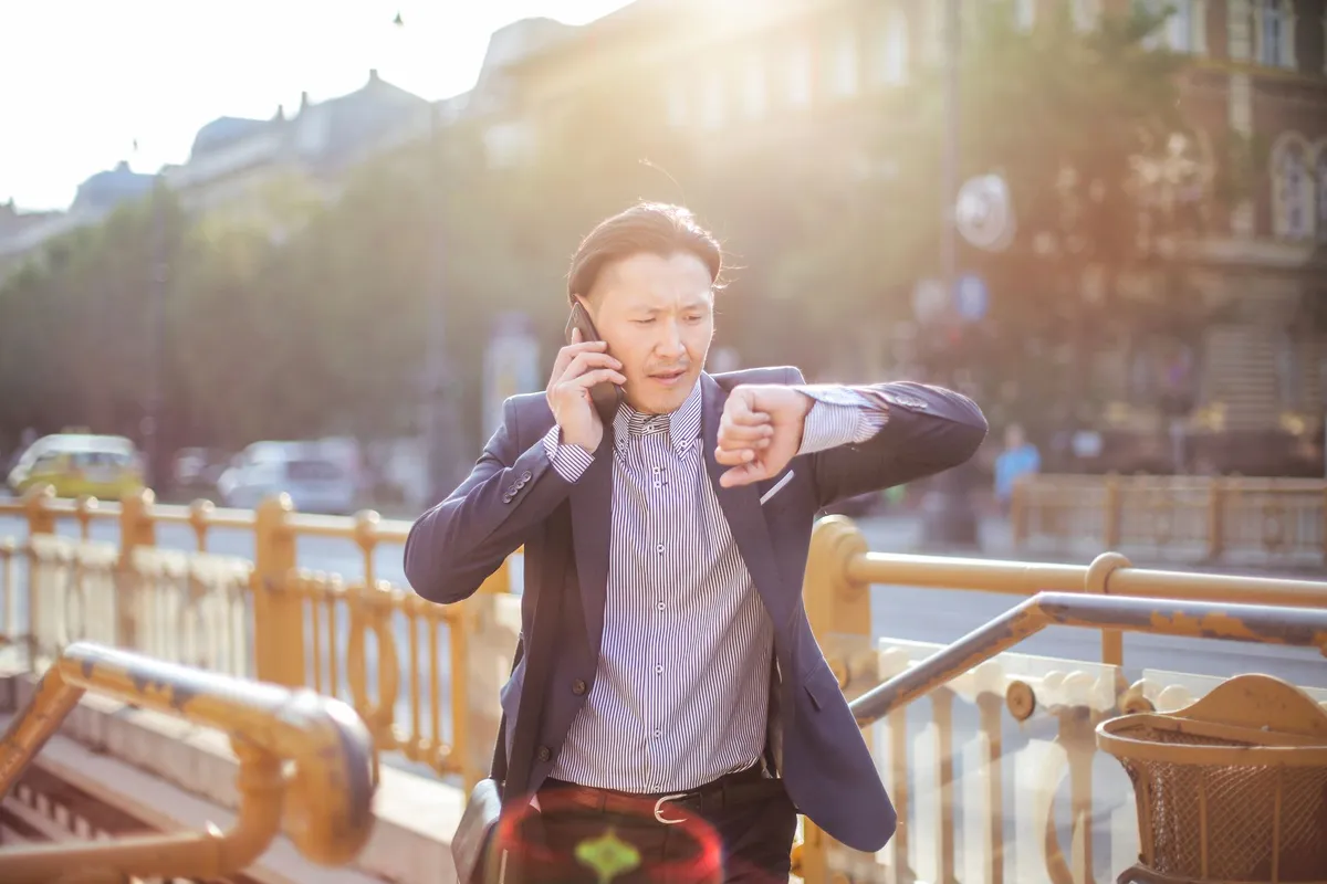 Businessman checking his watch while on the phone