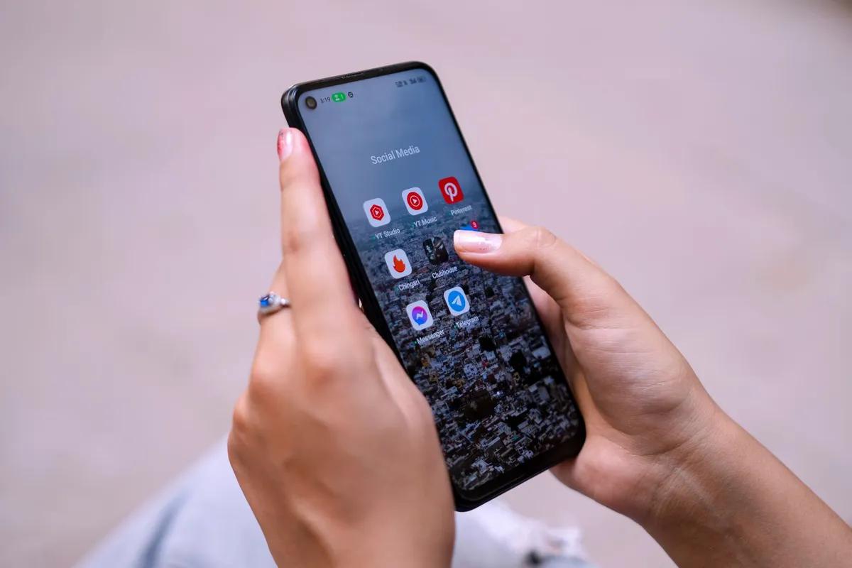 Close-up of hands holding a phone with communication apps